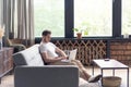 Typing new blog post. Handsome young man using his laptop with smile while sitting on the couch at home. Royalty Free Stock Photo