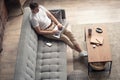 Typing new blog post. Handsome young man using his laptop with smile while sitting on the couch at home. Royalty Free Stock Photo