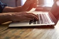 Typing on notebook computer, close up of hands of business man working on laptop. Side view, selective focus Royalty Free Stock Photo