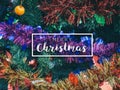 Typographical Merry Christmas Banner. Colorful Christmas background with Christmas ornament prop on Christmas tree Royalty Free Stock Photo