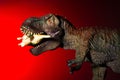 Tyrannosaurus biting a smaller dinosaur with spot light on the head and red light