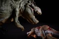 Tyrannosaurus in front of a stegosaurus body on dark