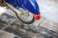 Tyre of motocross bike on ice and snow on background. Special winter tire with studs for riding on ice