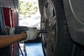 Tyre repairer fixing a wheel using an impact wrench Royalty Free Stock Photo