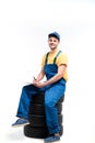 Tyre service worker sitting on a pile of tires