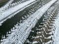 Tyre traces imprints on asphalt road. winter season. snowy texture
