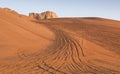 Tyre tracks inthe desert at sunrise Royalty Free Stock Photo