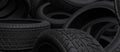 Tyres bulk header background. Black tires piles on a garage or store. 3D render illustration Royalty Free Stock Photo