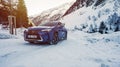 Blue hybrid car on the road side in snow and dangerous icy conditions.