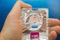 Tyumen, Russia - February 01, 2019: Durex condom in hand on blue background close-up