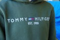 Tyumen, Russia-January 11, 2024: Person in Green Tommy Hilfiger Sweatshirt close up logo. Selective focus