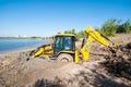 Tyumen, Russia, July 6, 2021: tractor, excavator, bulldozer stuck in sand and clay on the shore