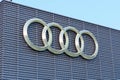 Tyumen, Russia-March 18, 2024: Audi logo are mounted prominently on a textured gray wall against a clear sky Royalty Free Stock Photo