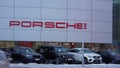 Tyumen, Russia-March 18, 2024: Vehicles parked outside a Porsche dealership, showcasing luxury cars and the iconic