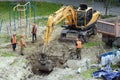 Tyumen, Russia, May 25, 2000: Repair works in the yard of a residential building. The excavator is digging a trench to lay water