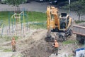 Tyumen, Russia, May 25, 2000: Repair works in the yard of a residential building. The excavator is digging a trench to lay water