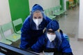 Tyumen, Russia, 07.14.2021. Medical workers or Doctors in masks and protective clothing view online data on a computer in the