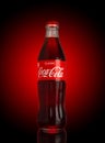 Coca-Cola Classic in a glass bottle on dark toned red Background. Coca Cola, Coke is the most Royalty Free Stock Photo