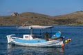 Tzia, Kea, Greece. Blue and white traditional fishing boat anchored in the middle of calm sea at Vourkari cove