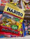 View on isolated package with Haribo gummy bears hold by hand in front of shelf