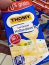 View on isolated package with Thomy sauces hollandaise hold by hand in front of shelf