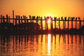 U Bein Bridge at sunset with people crossing Ayeyarwady River, M