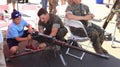 A U.S. Marine teaches a young boy how to use a machine gun