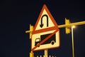 U-turn signs on the street at night Is a grain film image. U turn sign after sunset. View of dark, black sky