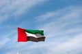 UAE flag waving in the sky, national symbol of UAE. UAE National Day.