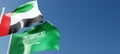 UAE and Saudi Arabia flags waving in the wind against a blue sky mockup with copy space. United Arab Emirates and Kingdom of Saudi