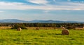 Autumn rural landscape with meadow, haystack, smaller village and hills on the background Royalty Free Stock Photo