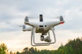UAV White drone Quadr copter in flight with geodesic module and digital camera explores the area on the background of a sunset Royalty Free Stock Photo