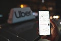 Uber app on phone with Uber taxi sign on background Royalty Free Stock Photo