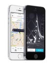 Uber app startup page and Uber search cars map on white and black Apple iPhones Royalty Free Stock Photo