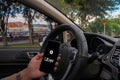 Uber driver holding smartphone in car. Uber is an American company offering transportation services online. Uber APP