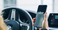 Uber driver holding smartphone in car. Uber is an American company offering different transportation services online Royalty Free Stock Photo