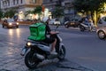 Uber Eats, boy with scooter, delivers food to home, with the typical green backpack