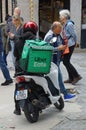 Uber Eats delivery driver waiting on scooter with insulated backpack Royalty Free Stock Photo