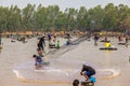 Ubon Ratchathani, Thailand - March 20, 2020 : Many Thai people casting a net for catching fish at river. Fishermen show ancient
