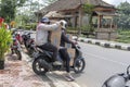 Two women is transporting goods on a motorbike on a street in Ubud, island Bali, Indonesia, close up