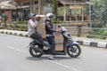 Two women is transporting goods on a motorbike on a street in Ubud, island Bali, Indonesia, close up