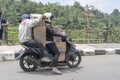 Two women is transporting goods on a motorbike on a street in Ubud, island Bali, Indonesia, close up