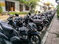 Ubud, Indonesia - December 2018: Many motorcycles and scooters parked in a line in the city of Ubud, Bali. Royalty Free Stock Photo