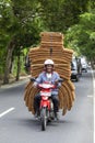 Man is transporting goods on a motorbike on a street in Ubud, island Bali, Indonesia, close up