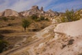 Uchisar, Cappadocia, Turkey: The road on the field goes to the city and the fortress of Uchisar. Rock houses and churches. Rock Royalty Free Stock Photo