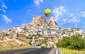 Uchisar castle, one of the most famous landmark in Turkey and one hot air balloon getting close to the castle Royalty Free Stock Photo