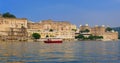 Udaipur City Palace on lake Pichola with tourist boat - Rajput architecture of Rajasthan. Udaipur, India