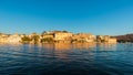 Udaipur cityscape at sunset. The majestic city palace on Lake Pichola, travel destination in Rajasthan, India Royalty Free Stock Photo