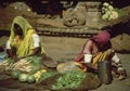 Rajasthani woman in colorful saree weighing vegetables