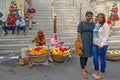 Contrast of young modern indian women and old traditional flower sales